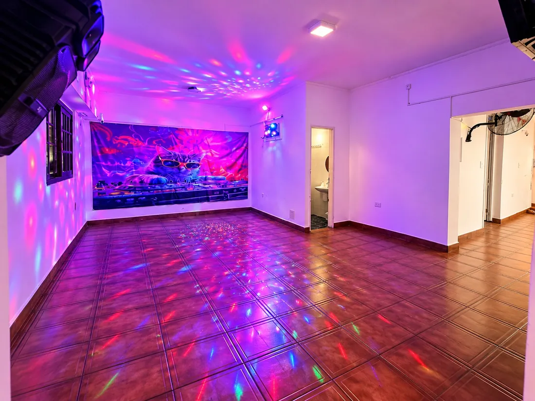 Sala de baile con luces de colores en el piso y el mural iluminado