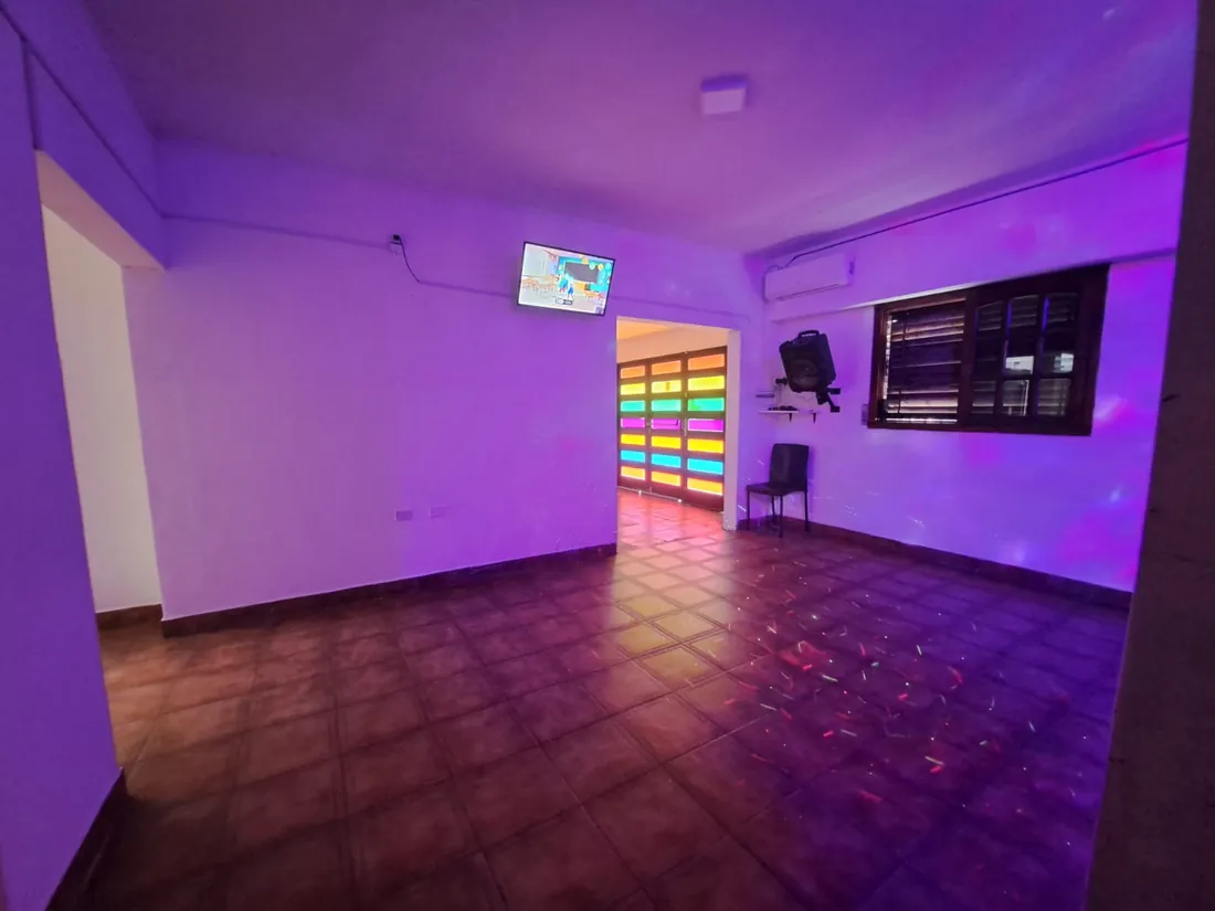 Sala de baile con luces violetas y la ventana de colores