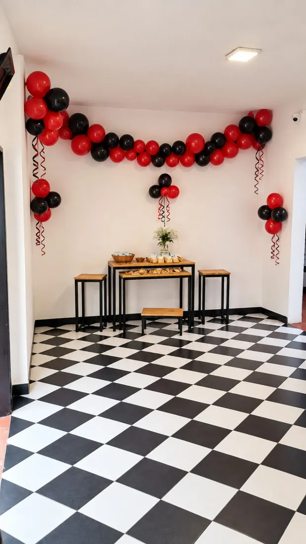 Rincón de la torta con piso a cuadros y guirnalda de globos
