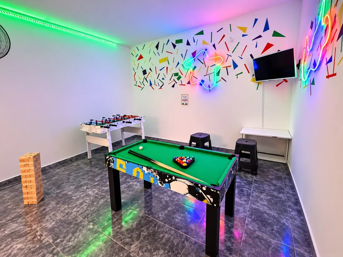 Sector gamer con mesa de pool, metegol, Jenga gigante y luces de neón