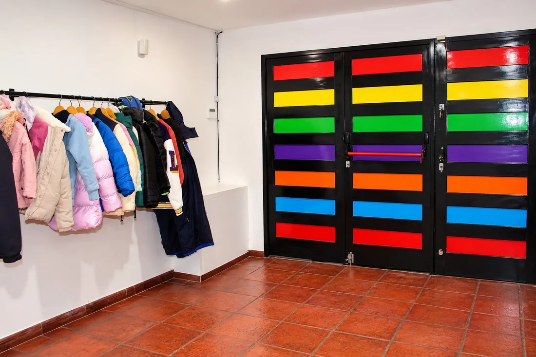 La puerta arcoíris de entrada y el perchero para los abrigos